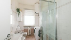 A modern bathroom with a glass shower enclosure, a built-in washing machine, and a toilet. - The Peak - Mountain view Aosta - Private parking! (Aosta)