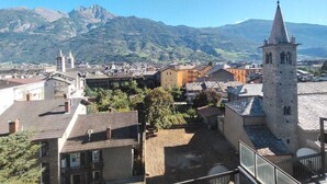 A town with a prominent church tower and a mountain backdrop. - The Peak - Mountain view Aosta - Private parking! (Aosta)