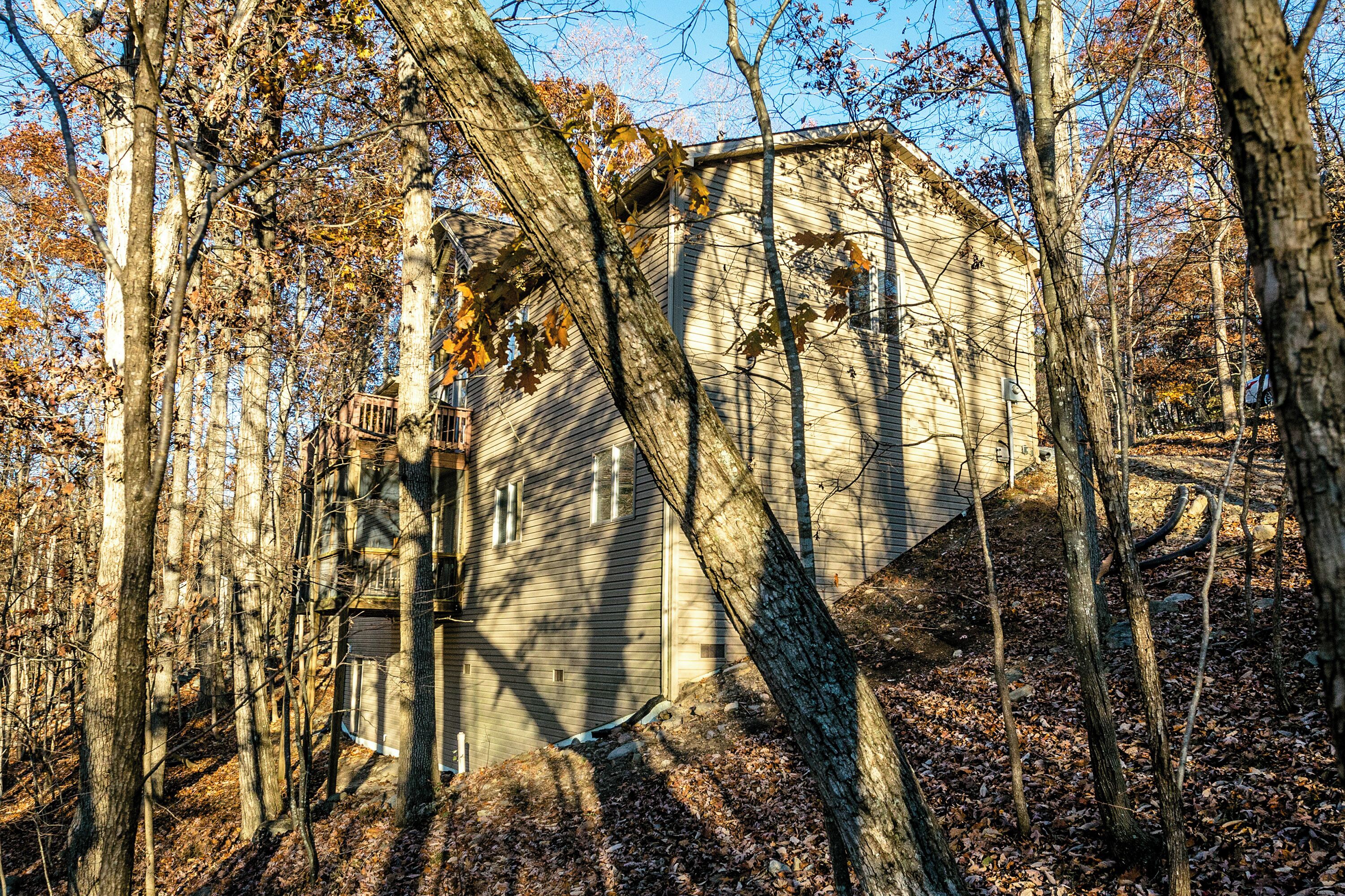 Una cabaña de madera rodeada de árboles bajo un cielo despejado.