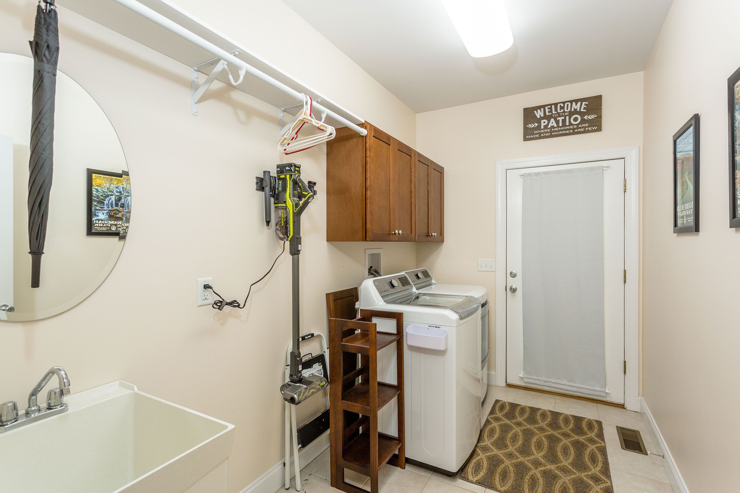 A compact laundry room with a washing machine, dryer, and a clothes drying rack.