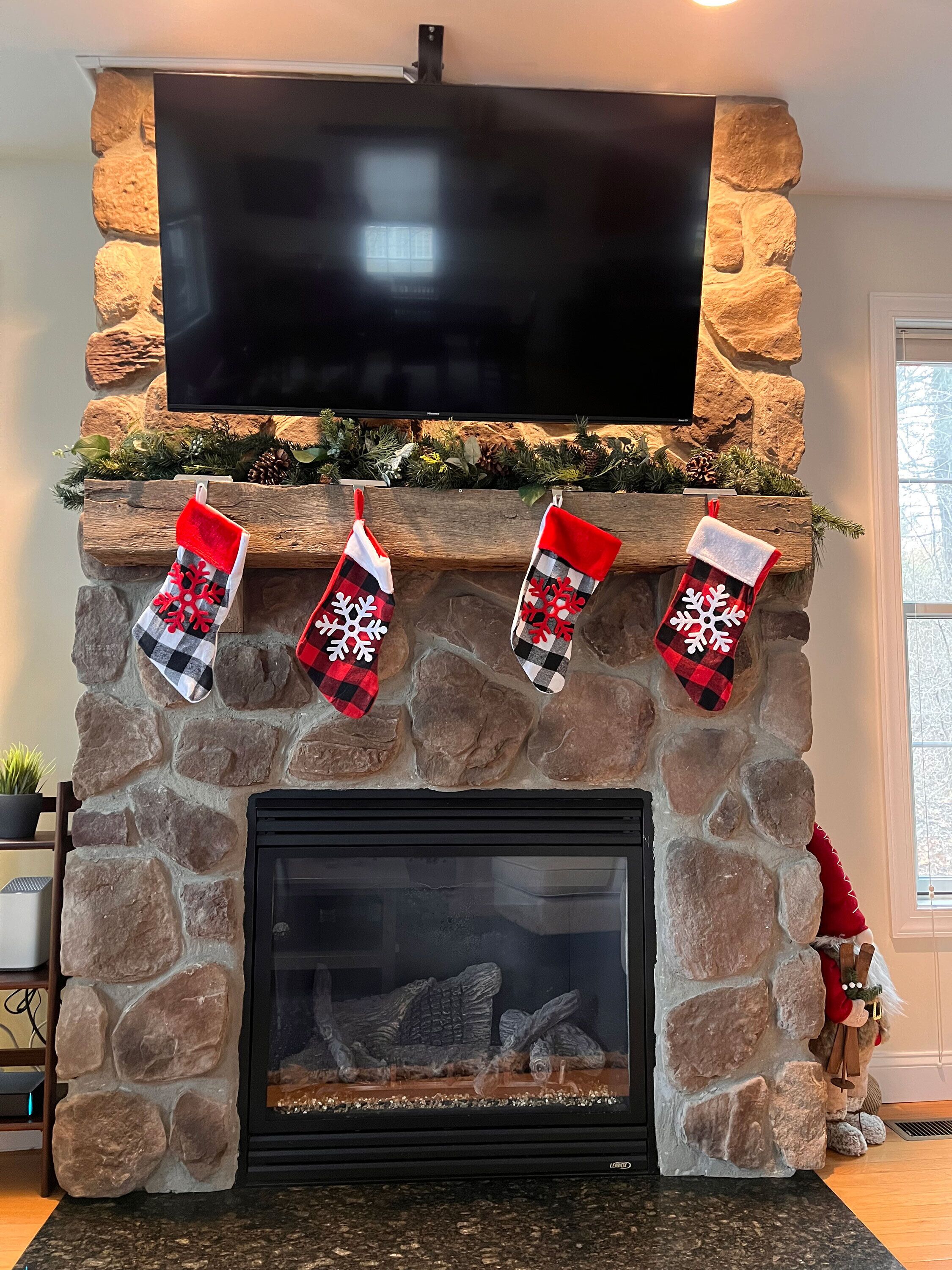 A stone fireplace with a flat-screen TV mounted above it.