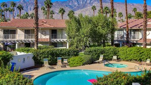 A hotel with a swimming pool, palm trees, and mountains in the background. - Stylish Condo With Panoramic View Community Pool (Palm Springs)