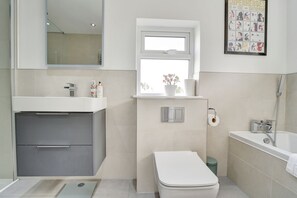 A modern bathroom with a toilet, sink, and shower. - Spacious 4 bedroom house in Bishop's Stortford (Hertfordshire)