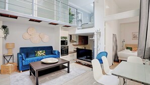 A modern apartment with a living room, dining area, kitchenette, and a balcony.
