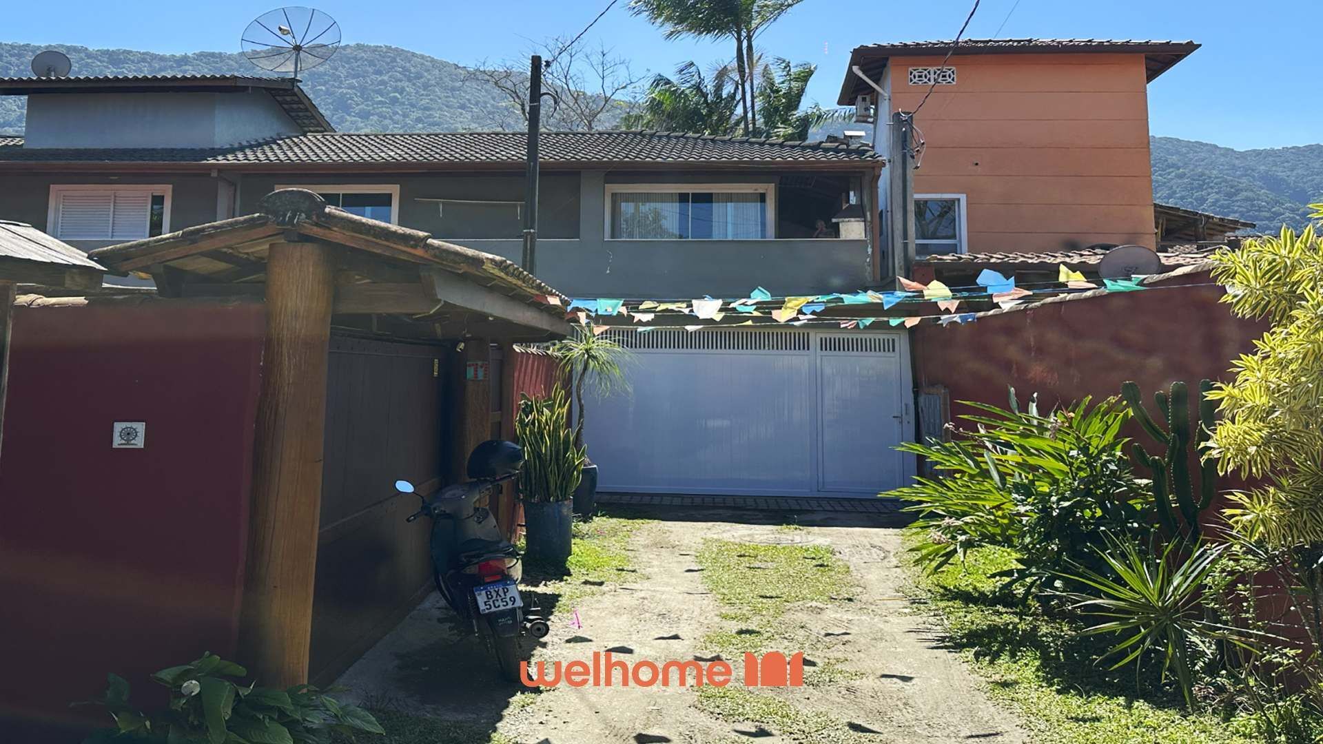 A residential property with a garage, a motorcycle, and a fenced yard.