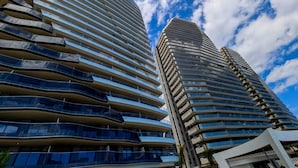 Two high-rise buildings with curved balconies and reflective glass facades.