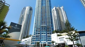 A high-rise building with a modern design, featuring multiple balconies and a prominent glass facade. - Level 30 Renovated Apt with Hot Tub & Netflix (Surfers Paradise)