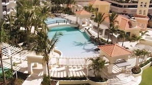 A resort with a central pool, palm trees, and a gazebo. - Level 30 Renovated Apt with Hot Tub & Netflix (Surfers Paradise)