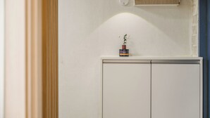 A white wardrobe with a small plant on top.