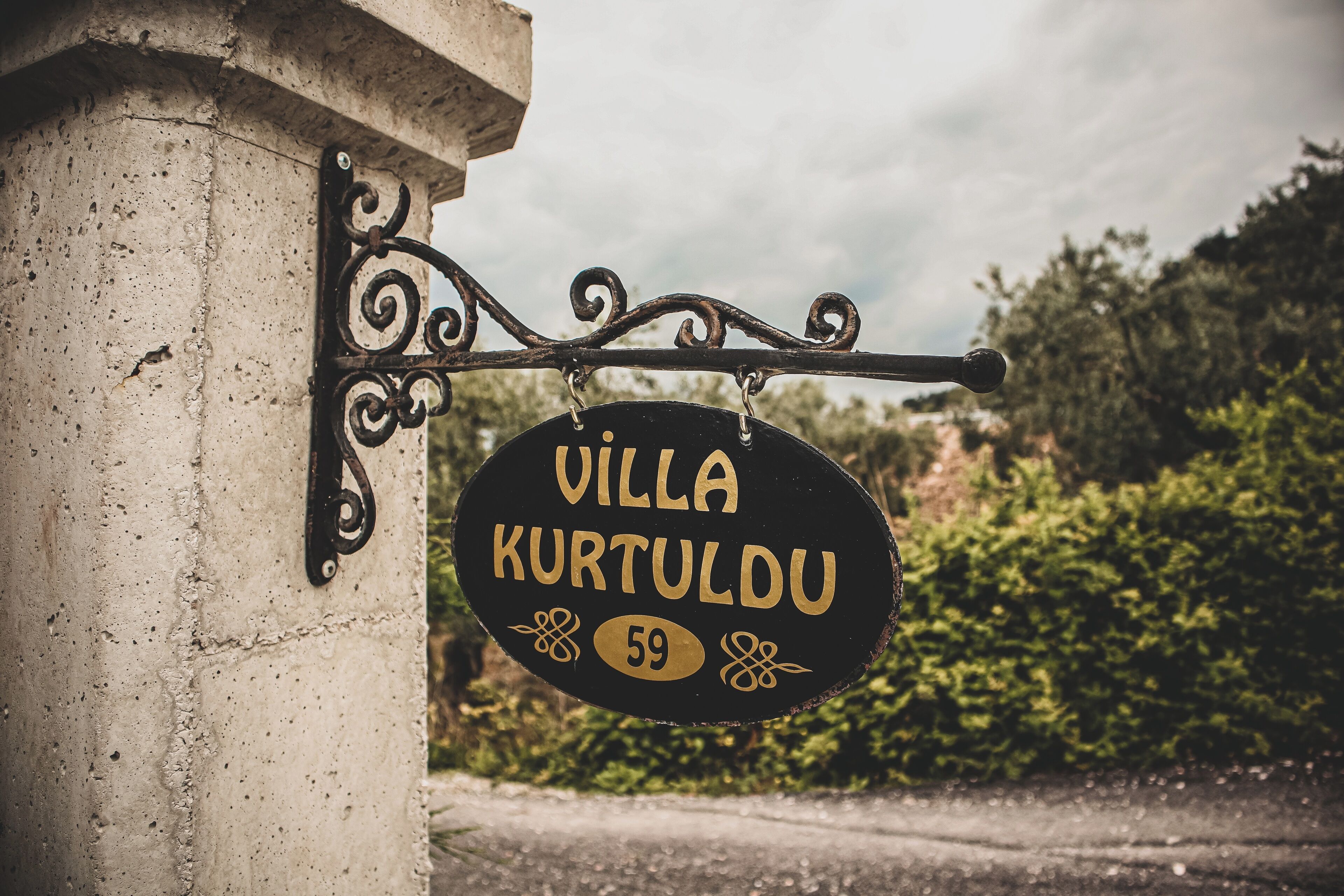 Un panneau indiquant « Villa Kurtuldu » avec le numéro 59.