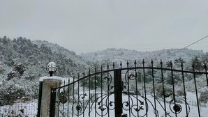 Un paysage enneigé avec une porte en métal et un panneau indiquant « Court Villa ».