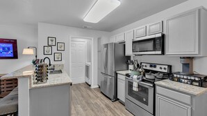 A modern kitchen with stainless steel appliances, a granite countertop, and a built-in oven.