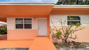 A single-story house with a flat roof, a front door, and a small porch area.