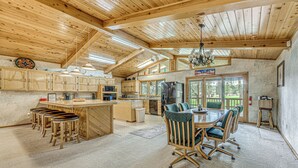 A spacious kitchen with wooden cabinets, a central island, and bar stools. - Hot Tub & Deck: Home 1 Mi to Ruidoso River! (Ruidoso)