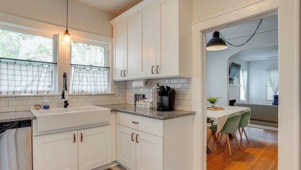 A modern kitchen with white cabinets, a granite countertop, and a coffee maker. - Home w/ Private Yard < 2 Mi to Hollis Garden! (Lakeland)
