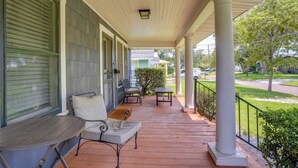 A covered porch with a table and chairs, a bench, and a view of the street. - Home w/ Private Yard < 2 Mi to Hollis Garden! (Lakeland)