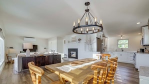 Una cocina amplia con una isla central, armarios blancos y una chimenea.