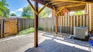 A covered outdoor area with a wooden structure, a brick floor, and a fence. - Close to Hospital & Dulles: Herndon Townhome (Herndon)