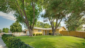 A two-story house with a front yard, a wooden fence, and a driveway. - Quiet & Convenient Sparks Retreat Near I-80 & Reno (Sparks)