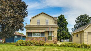 A two-story house with a front porch, a small front yard, and a garage.