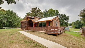 Un chalet rustique doté d’une terrasse en bois et d’un porche abrité.