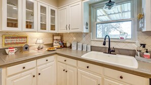 A kitchen with white cabinets, a sink, and a window with a view. - Boqsue River Valley Views! 3-acre Country Home (Valley Mills)