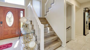 A staircase with wooden steps and white railings, leading to an upper floor.