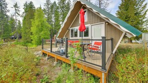Een chalet met terras, buiten zitplaatsen en uitzicht op het omliggende bos.