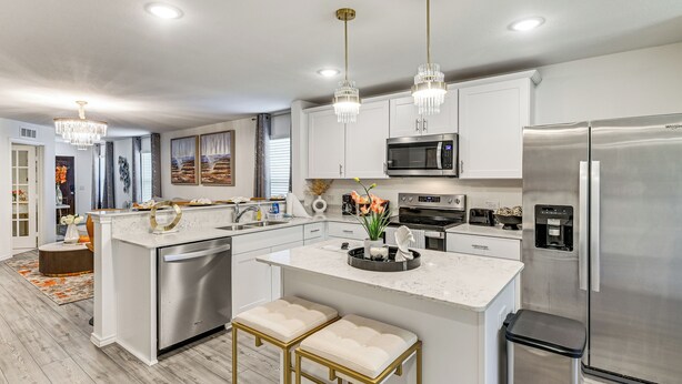 A modern kitchen with stainless steel appliances, white cabinetry, and a central island with bar stools. - Modern Comforts + Fenced Yard: Princeton Retreat! (Princeton)
