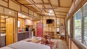 Une chambre d’hôtel comprenant un lit, un coin repas, une cuisine et un téléviseur.