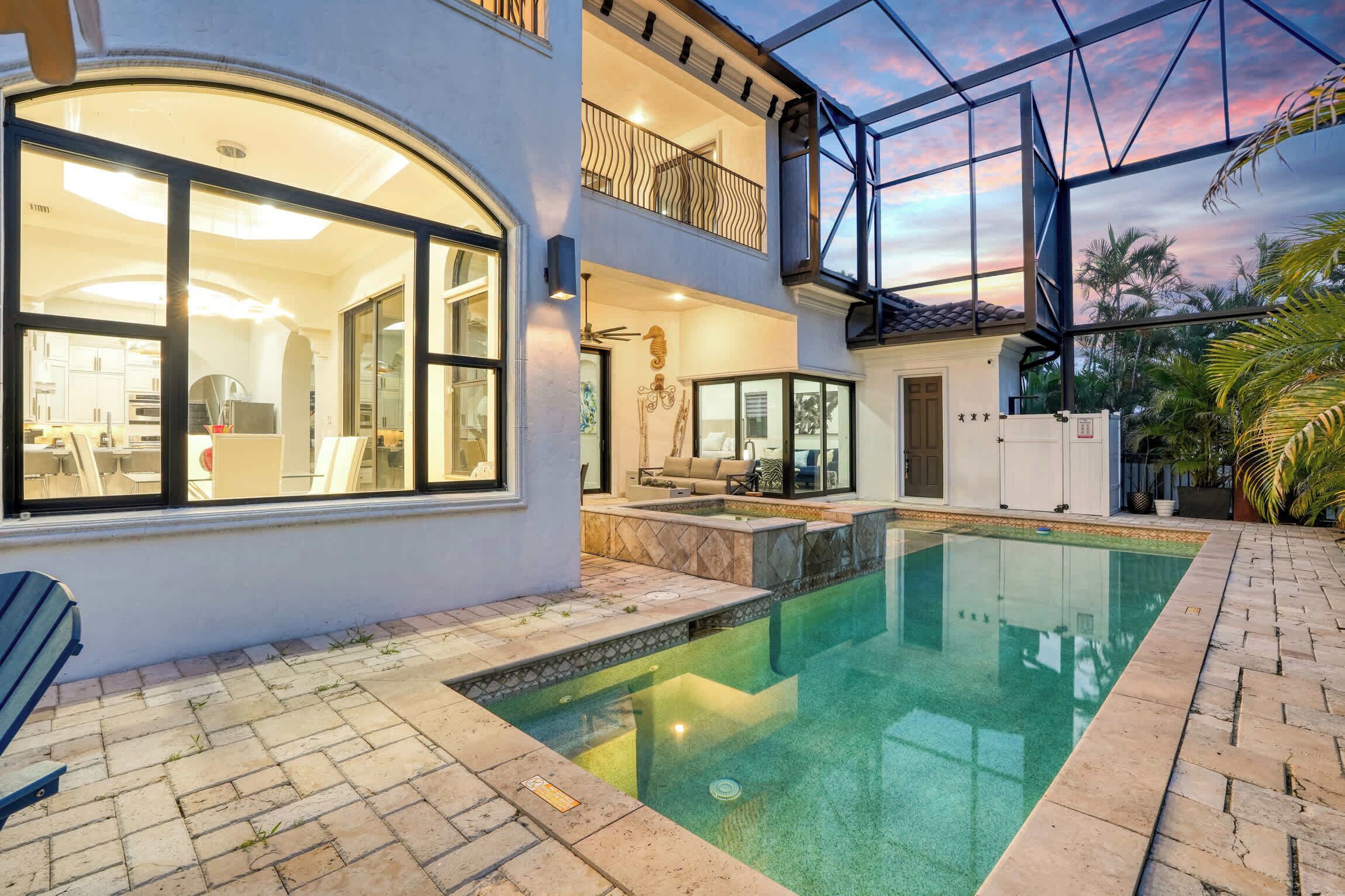 Una casa de dos plantas con piscina, balcón y zona de patio.