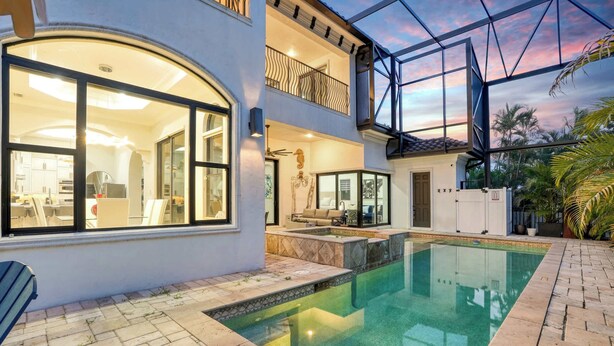 Une maison à deux étages avec une piscine, un balcon et un patio.