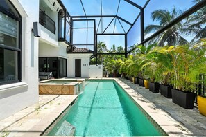 A modern house with a swimming pool, large windows, and a balcony. - Spacious Luxury Waterfront Retreat with Pool & Spa (Naples)