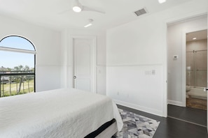 A bedroom with a bed, a door, a window, and a view of the outside. - Spacious Luxury Waterfront Retreat with Pool & Spa (Naples)