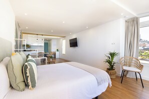 Een moderne hotelkamer met een groot bed, een zithoek en een televisie.
