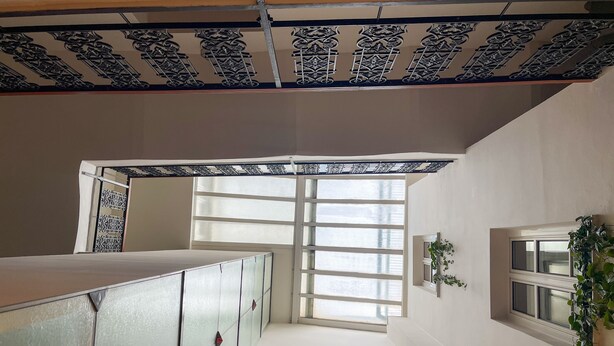 A room with a balcony, a window with a view, and a decorative metal partition. - Hotel 16 & Apartments Prague City Living (Prague)