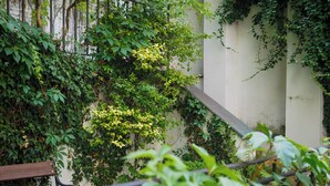 A wooden bench and a staircase surrounded by lush greenery and vines. - Hotel 16 & Apartments Prague City Living (Prague)