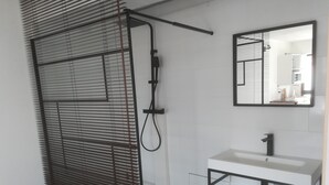 A modern bathroom with a bathtub, a sink, and a mirror. - Studio No. 1 (Le Trait)