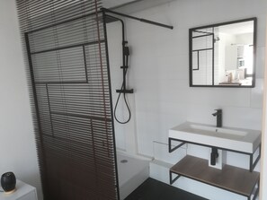A modern bathroom with a bathtub, a sink, and a mirror.