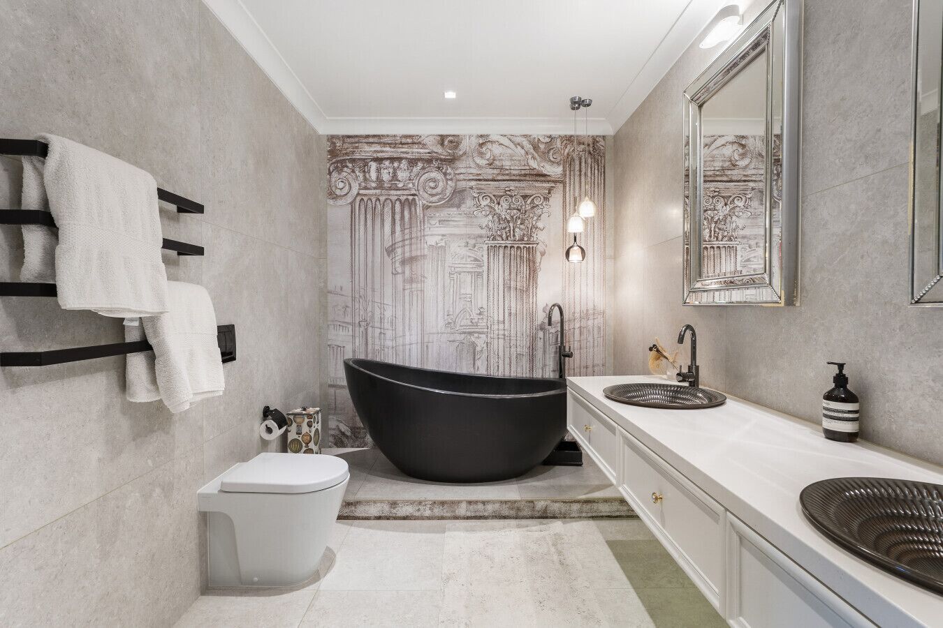 A modern bathroom with a freestanding bathtub, a large mirror, and a white vanity.