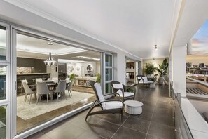 A modern apartment with a dining area, living room, and balcony with city views.