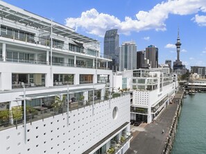 A modern building with multiple floors, large windows, and a waterfront view.