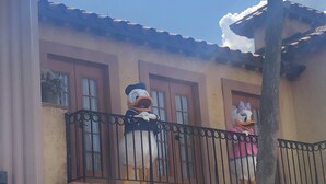 Ein Gebäude mit einem Balkon, der zwei große Statuen von Zeichentrickfiguren zeigt.
