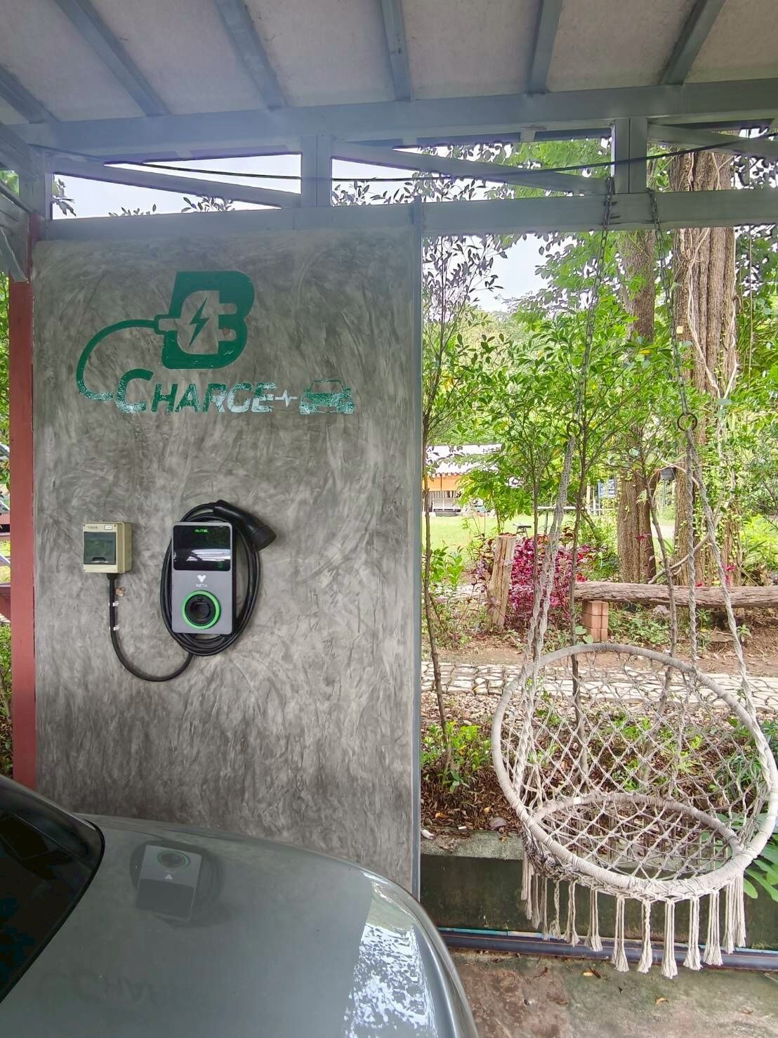 Una estación de carga para vehículos eléctricos con un cable de carga conectado a un automóvil.