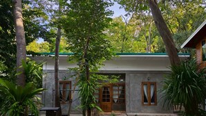 A house with a paved courtyard, a wooden door, and a window with curtains. - Phawaeng Resort (Uthai Thani)