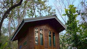 A wooden cabin with a balcony and a staircase leading to an upper level. - Phawaeng Resort (Uthai Thani)