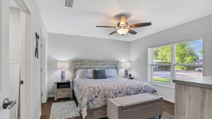 A bedroom with a bed, bedside lamps, a ceiling fan, a window, and a view of the outside. - Sparkling 3-bedroom house with AC in Palatka (Palatka)
