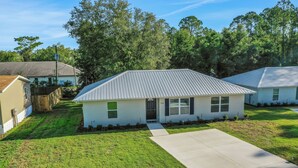 A single-story house with a metal roof, a front porch, and a well-maintained lawn. - Sparkling 3-bedroom house with AC in Palatka (Palatka)