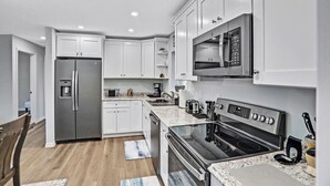 A modern kitchen with white cabinets, stainless steel appliances, and granite countertops. - Sparkling 3-bedroom house with AC in Palatka (Palatka)