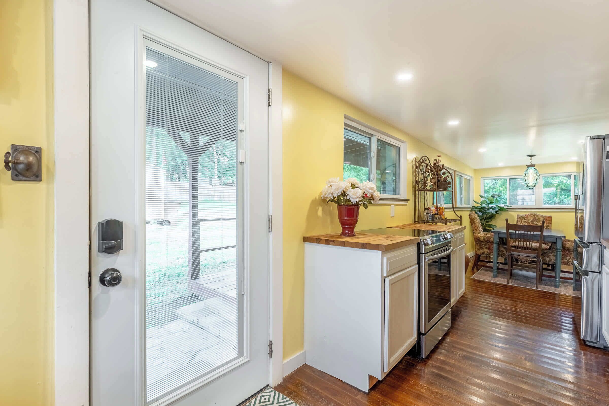 A kitchen with a built-in oven, a dining area with a table and chairs, and a refrigerator.